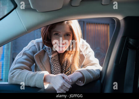 Caucasian woman leaning on car door Stock Photo