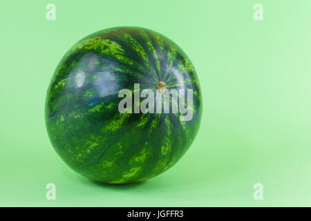 Tiny watermelon isolated on green background Stock Photo