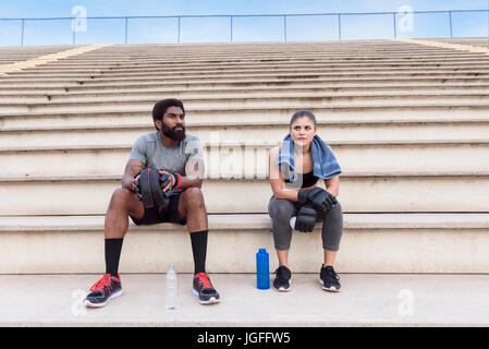 Trainer and woman resting on bleachers Stock Photo