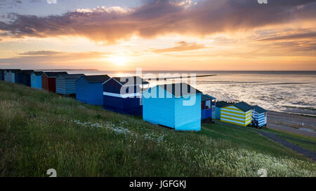 Whitstable beach huts on Tankerton slopes at sunset. Stock Photo