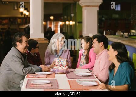 Family celebrating birthday of older woman in restaurant Stock Photo