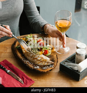 Woman eating fish with white wine Stock Photo