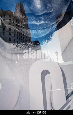 Telefonica buliding reflection on a window shop poster in Gran Via Avenue. Madrid. Spain Stock Photo