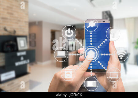 Smart home automation app on mobile with home interior in background. Internet of things concept at home. Smart technology 4.0 Stock Photo