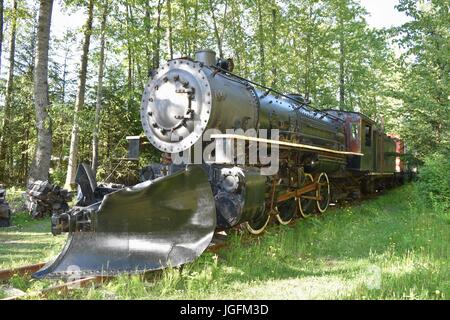 Abandoned steam locomotive with a snowplow blade. Stock Photo