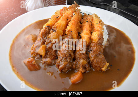 Rice with deep fried shrimp and curry in Japanese style or ebi kare in white  plate ready to eat. Stock Photo