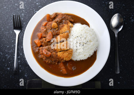 Rice with deep fried pork and curry in Japanese style or katsu kare in white  plate ready to eat. Stock Photo