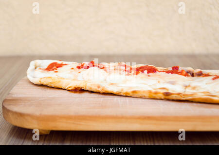 Pizza Calzone on wooden board side view Stock Photo