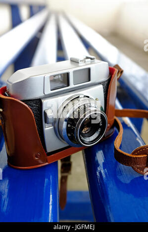 old retro style 35mm rangefinder camera on blue painted bench Stock Photo