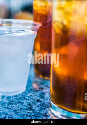 Macro closeup of two plastic cups with ice and condensation on table with straws Stock Photo