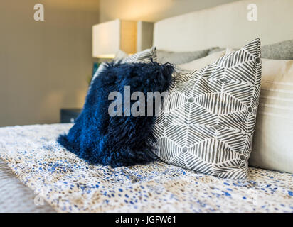 Closeup of new bed comforter with decorative pillows in bedroom Stock Photo