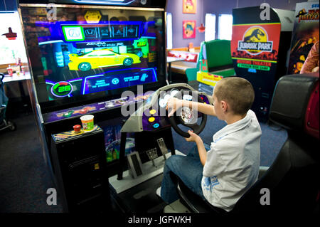 Boy playing an arcade video game. Stock Photo