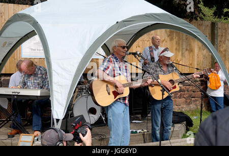 Liverpool, UK. 6th July 2017 marked the 60th anniversay when John Lennon, playing in his skiffle group The Quarry Men(or Quarrymen), first met Paul McCartney at St.Peters Church Hall in Woolton, Liverpool.     The Quarry Men recreated the procession on the back of a lorry around the village and also played at the Bishop Martin CP school fete.       Saint Peters Church and the Church Hall were also open to the public with a variety of festivities.  Photo show The Quarrymen playing at the Bishop Martin CE Primary School fete. Credit: Pak Hung Chan/Alamy Live News Stock Photo