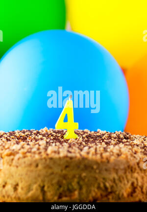Homemade cake with number four candle and balloons background. Stock Photo