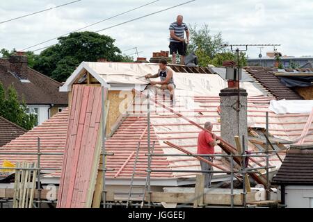 Builders constructing a loft extension on a suburban bungalow in Shepperton Surrey UK Stock Photo
