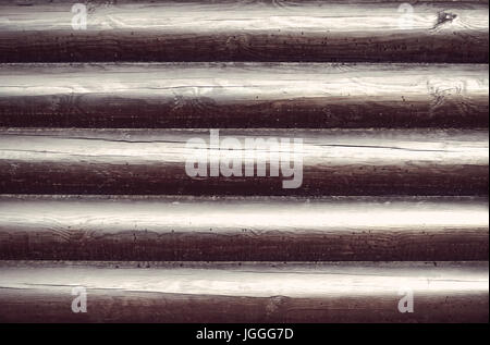 Wooden wall from logs as a background texture. Blackened timber covered with varnish Stock Photo