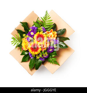 Flower delivery. Bouquet of rose and gerbera flowers in cardboard box isolated on white background clipping path included. Flat lay, top view Stock Photo