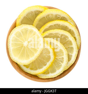 Lemon slices in wooden bowl. Fresh cut ripe yellow edible citrus fruit discs. Citrus limon Osbeck. Isolated macro food photo close up from above. Stock Photo