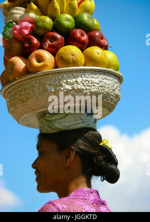 Woman carrying offerings on her head during a traditional hindu temple festival procession, Bali island, Canggu, Indonesia Stock Photo