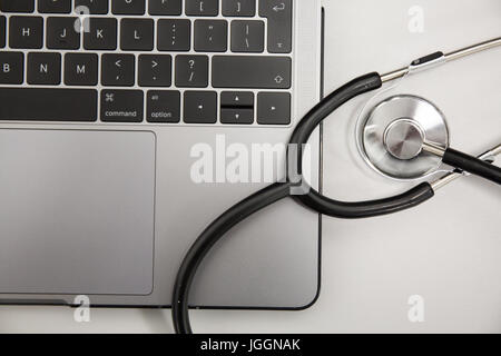 Doctors stethoscope resting on a laptop computer Stock Photo