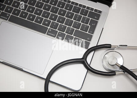 Doctors stethoscope resting on a laptop computer Stock Photo