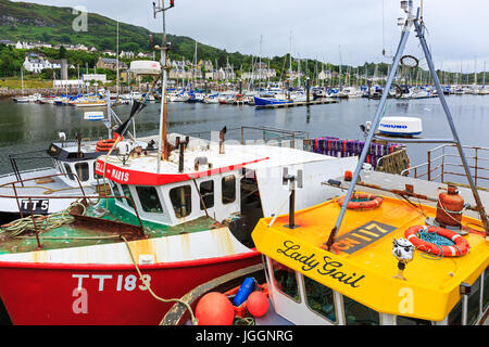 Fishing boats tied up at Tarbert harbour, Loch Fyne with yachts in the marina behind. Scotland, UK Stock Photo