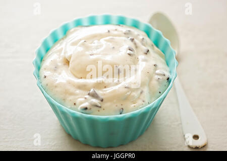Stracciatella yogurt in small bowl with white spoon Stock Photo