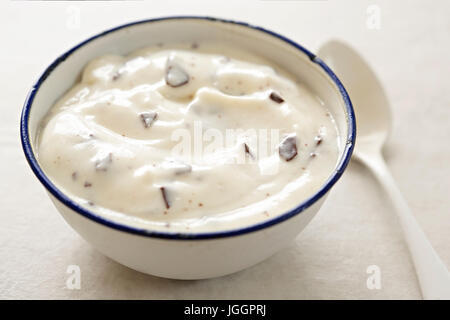 Stracciatella yogurt in small bowl with white spoon Stock Photo