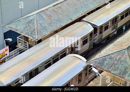 On tracks that gave rise to the term Loop in Chicago's famous downtown area, a pair of CTA rapid transit trains meet. Chicago, Illinois, USA. Stock Photo
