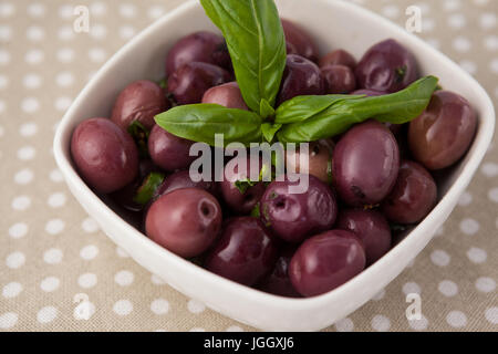 Close up of brown olives with herb on napkin Stock Photo