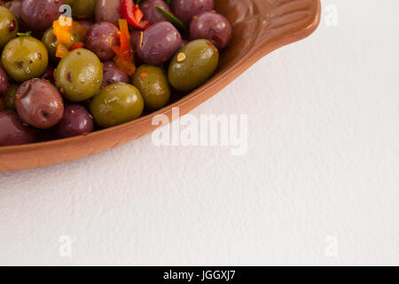 Cropped image of olives served in container on table Stock Photo