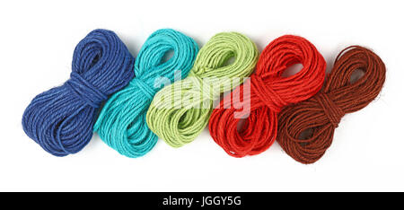 Group of five small coil skeins of natural colorful multicolor jute twine rope, selection of green, blue red, brown and teal, isolated on white backgr Stock Photo