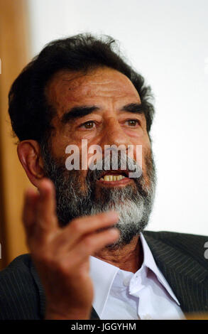 Former President of Iraq, Saddam Hussein, makes a point during his initial interview by a special tribunal, where he is informed of his alleged crimes and his legal rights. Stock Photo