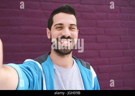 Young latin man taking a selfie. Technology concept. Stock Photo