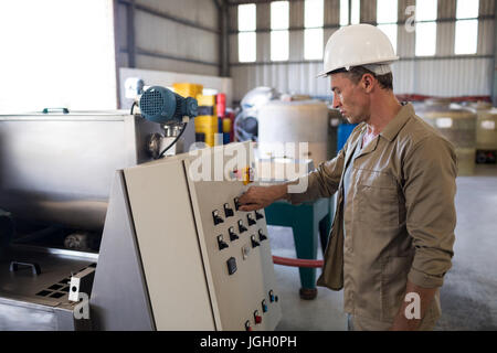 Attentive technician operating a machine in oil factory Stock Photo