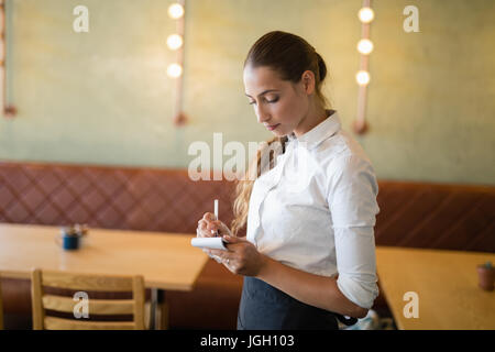 Waitress taking an order on notepad in bar Stock Photo