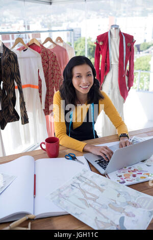 Female designer using laptop in office Stock Photo