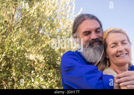 Romantic couple standing in olive farm on a sunny day Stock Photo