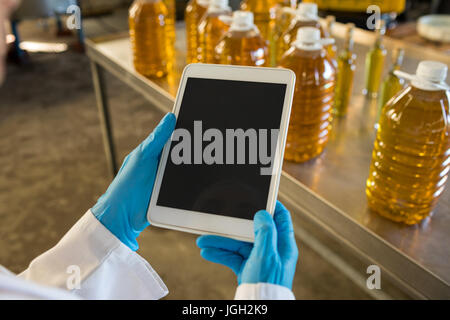 Mid section of technician using digital tablet in oil factory Stock Photo