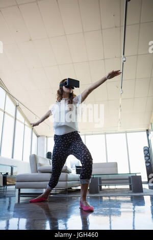 Low angle view of businesswoman wearing virtual reality simulator exercising in office Stock Photo