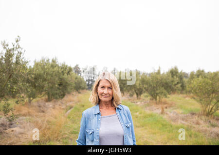 Portrait of happy woman standing in olive farm Stock Photo