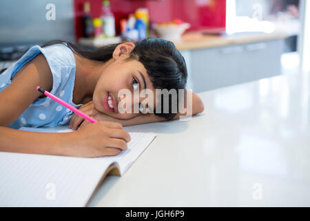 High angle portrait of girl doing homework at kitchen counter Stock Photo