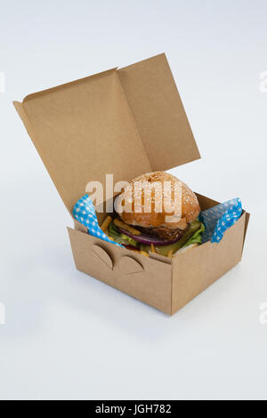 Hamburger in a take away container on table against white background Stock Photo