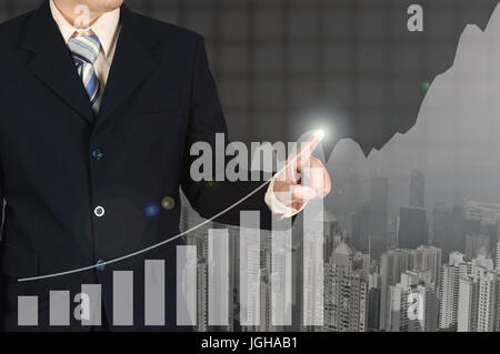 Double exposure businessman hand touching virtual panel of growth bar chart on financial graph chart and building background, business success concept Stock Photo
