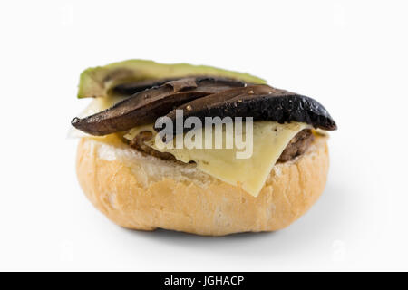Close up of vegetables with cheese on bun against white background Stock Photo