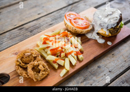 High angle view of French fries with sauce and burger Stock Photo