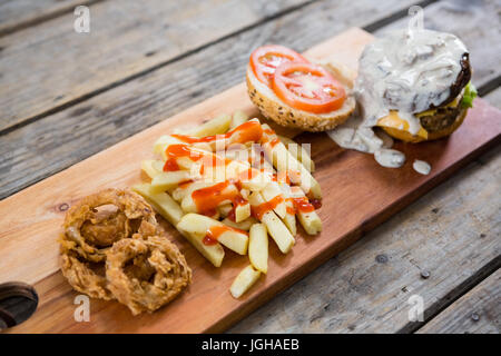 High angle view of burger and French fries with drink on white ...