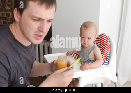 Father feeding infant son Stock Photo