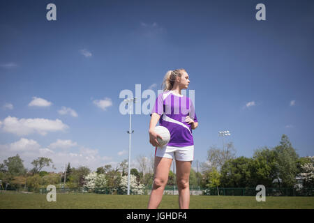 Female soccer player with ball looking away on field Stock Photo