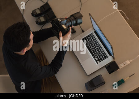 High angle view of photographer adjusting camera at table in studio Stock Photo